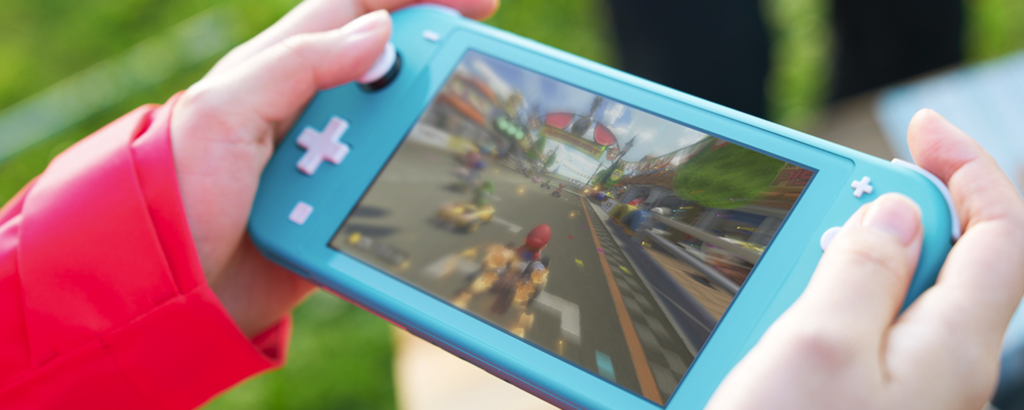 女性がニンテンドースイッチライトを持ってゲームをしている
