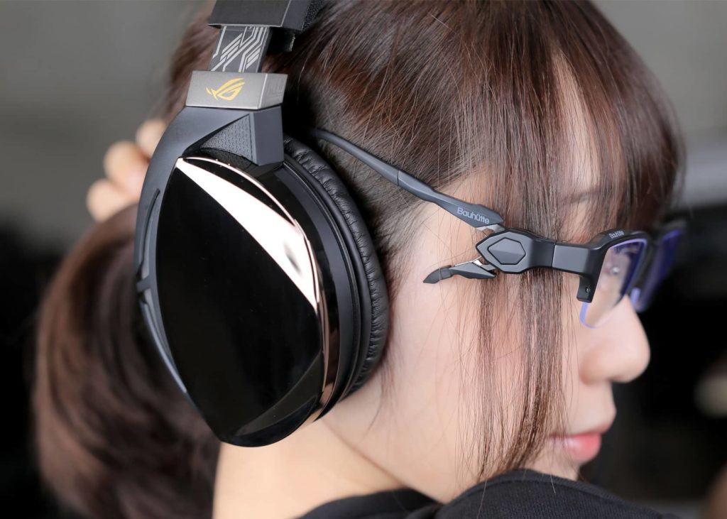 女性がゲーミングメガネをかけてヘッドホンを付けている